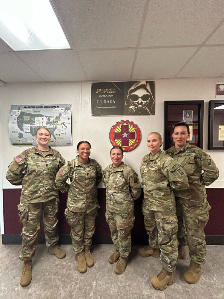 Melissa Novotny (left) pictured with fellow soldiers.